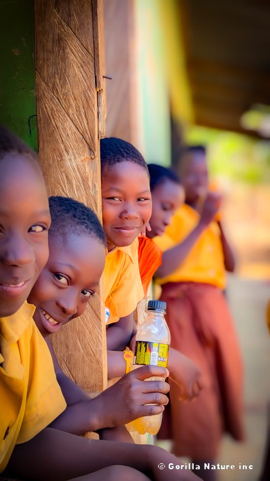 School children smiling from a doorway